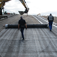 Excavator uses a spreader beam for precise installation of the GTD on a construction site