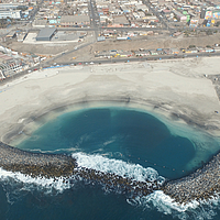 Zwei großformatige SoilTain Tubes gänzlich überdeckt mit Wasserbausteinen als Wellenbrecher im Meer