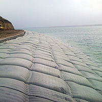 Sandsäcke am Wasserrand für Uferschutz