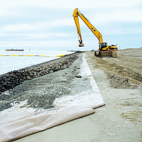 Ausgrabungsarbeiten am Strand für die Platzierung von Steinen