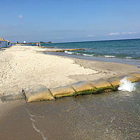 SoilTain Bags an der Küste eines touristischen Sandstrandes