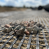 Nahaufnahme von Basetrac Grid Geogitter mit kleinen Steinchen darauf