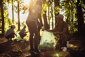 Freiwillige sammeln Plastikflaschen im Wald zur Herstellung von Fortrac T eco Geogittern aus 100% recyceltem PET