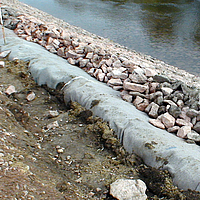 Geotextiles Vliesstoff und Steine am Wasserrand für Uferschutz