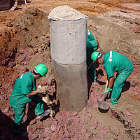 Arbeiter schaufeln an einer mit Ringtrac® ummantelten und befüllten Säule