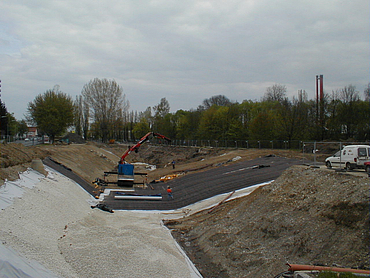 Geosynthetische Tondichtungsbahnen werden mit Kies bedeckt 