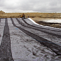 Ausrollen von Basetrac Grid Geogitter mit einer Tragtraverse zur Tragschichtbewehrung auf einer Baustelle