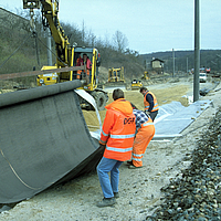 Laying the NaBento bentonite mat with the help of an excavator