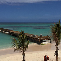 SoilTain Tube unter einer Pier im Wasser an einem touristischen Strand als Wellenbrecher