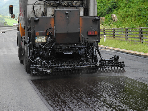 Bitumenemulsion wird auf die Fahrbahn gesprüht