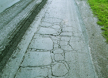 Alte Landstraße mit vielen Rissen in der Oberfläche 
