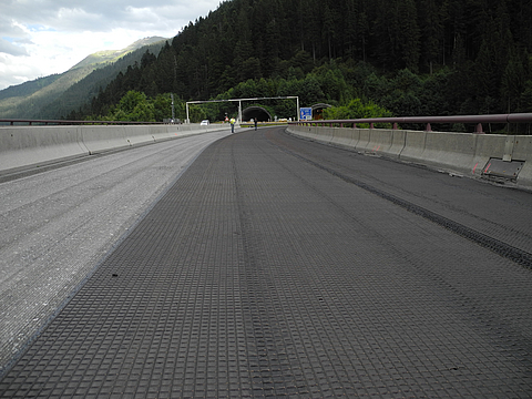 Autobahn durch bergige Landschaft mit offener Teerdecke