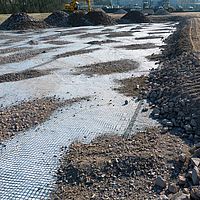 Basetrac Grid auf Baustelle mit partieller Abdeckung durch Sand und Kies